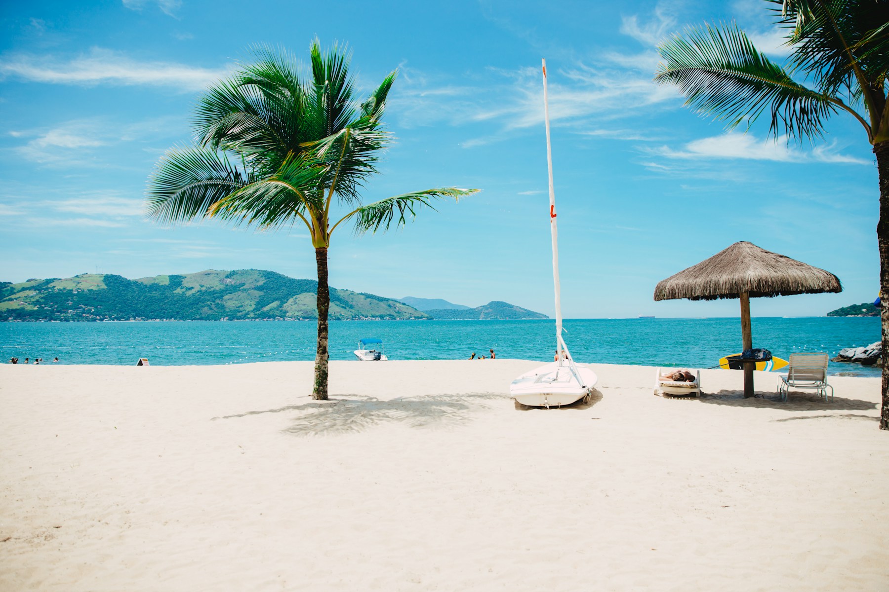 Tropical Florida beach with palms and a sailboat