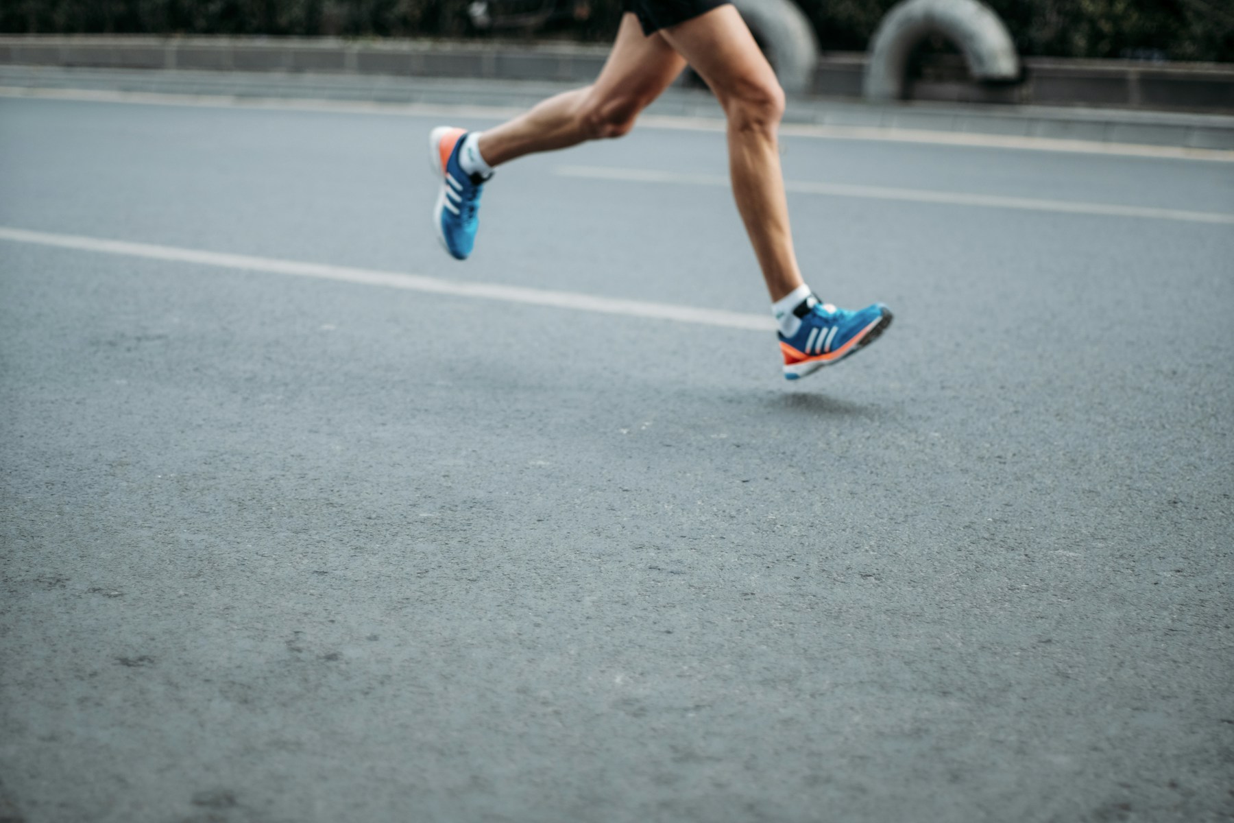 A runner mid-stride on a paved trail